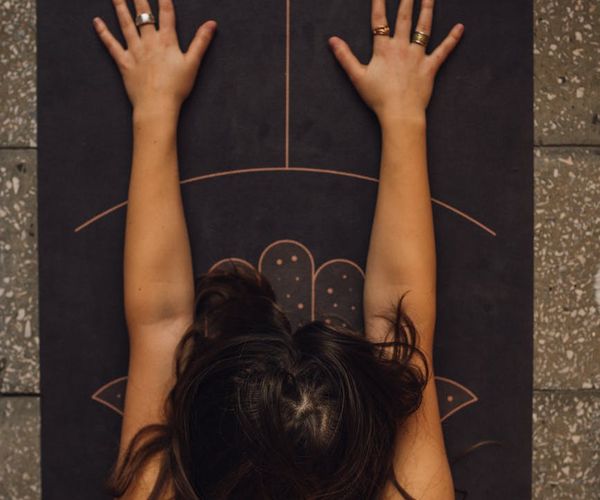 A person of average fitness comfortably performing a stretch on a yoga mat.