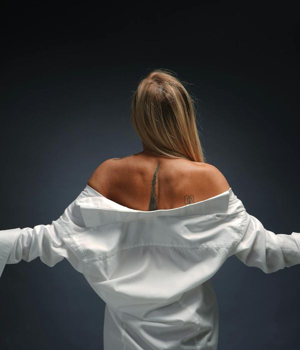 Woman in a graceful yoga pose against a minimal dark background, conveying peace.